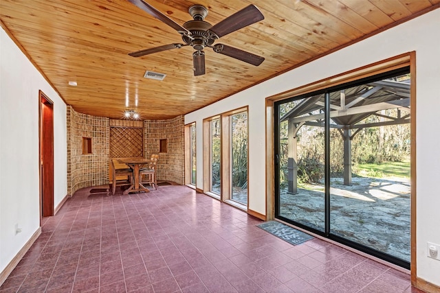 unfurnished sunroom with a ceiling fan, wooden ceiling, and visible vents