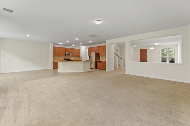 unfurnished living room featuring light carpet