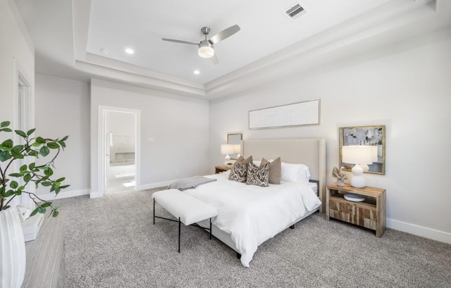 carpeted bedroom with connected bathroom, ceiling fan, and a tray ceiling