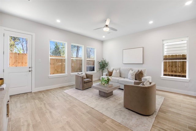 living room with light hardwood / wood-style flooring and ceiling fan