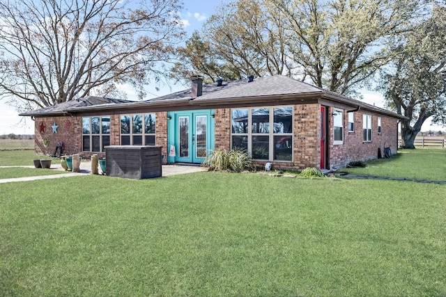 back of house featuring french doors and a lawn