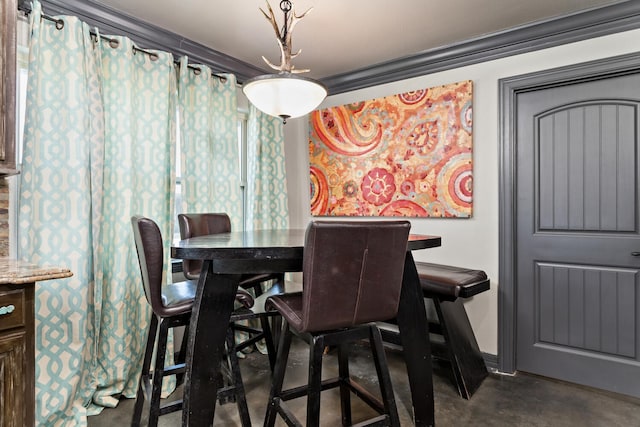 dining space featuring ornamental molding and concrete flooring