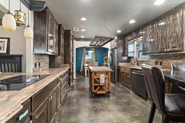 kitchen featuring dark brown cabinetry, hanging light fixtures, tasteful backsplash, and stainless steel appliances