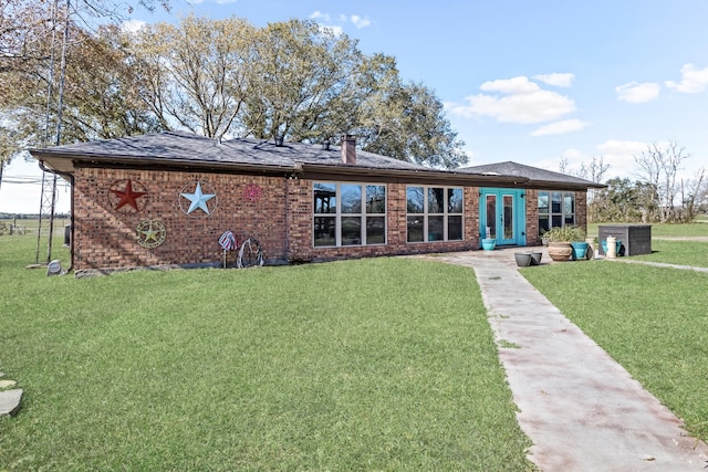 back of house featuring a yard and french doors