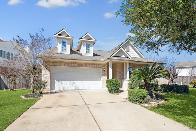 view of front of property with concrete driveway, a front lawn, fence, and brick siding