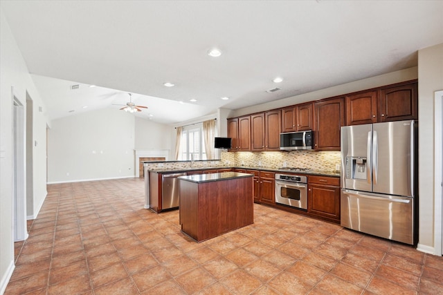 kitchen with a kitchen island, a peninsula, vaulted ceiling, stainless steel appliances, and backsplash