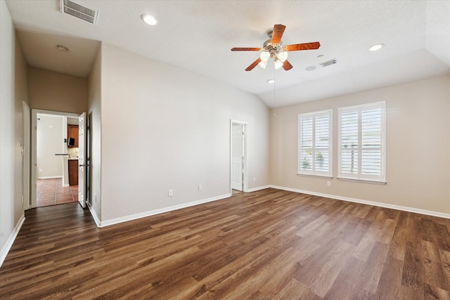 spare room with lofted ceiling, baseboards, visible vents, and dark wood-style flooring