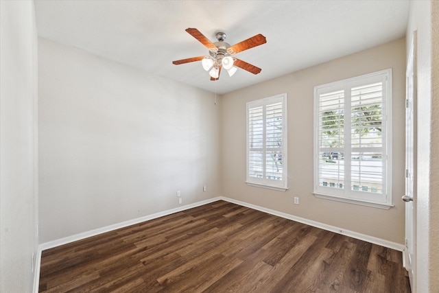 unfurnished room with dark wood-type flooring, a wealth of natural light, and baseboards