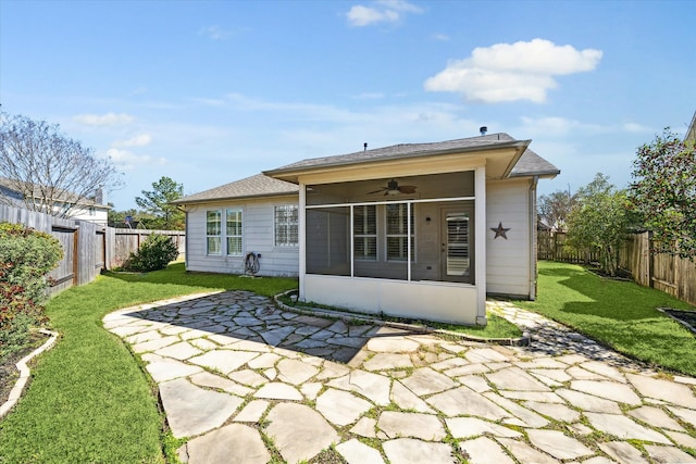 rear view of house with a sunroom, a fenced backyard, ceiling fan, a yard, and a patio area