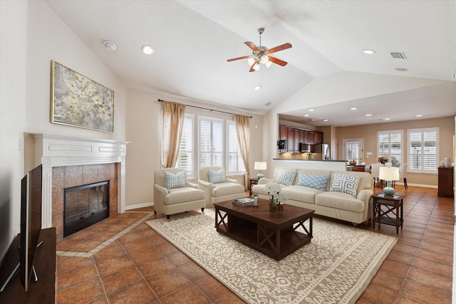 living area featuring lofted ceiling, a tiled fireplace, a wealth of natural light, and recessed lighting