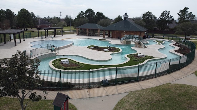 community pool with a patio area, fence, and a gazebo