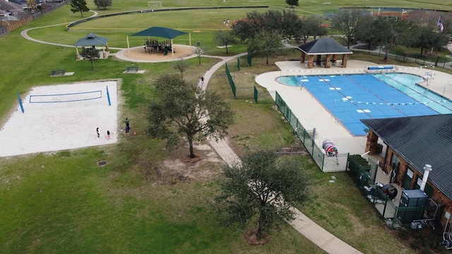 community pool with volleyball court, fence, and a gazebo