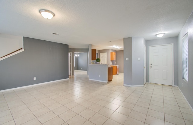 unfurnished living room featuring light tile patterned floors and a textured ceiling