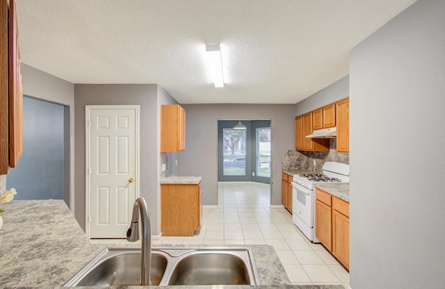 kitchen with sink, light tile patterned floors, a textured ceiling, white range with gas cooktop, and decorative backsplash