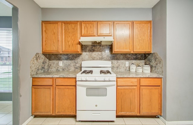 kitchen with tasteful backsplash, light tile patterned flooring, and gas range gas stove