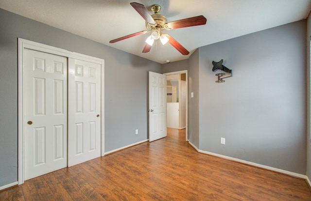 unfurnished bedroom with ceiling fan, dark hardwood / wood-style floors, and a closet