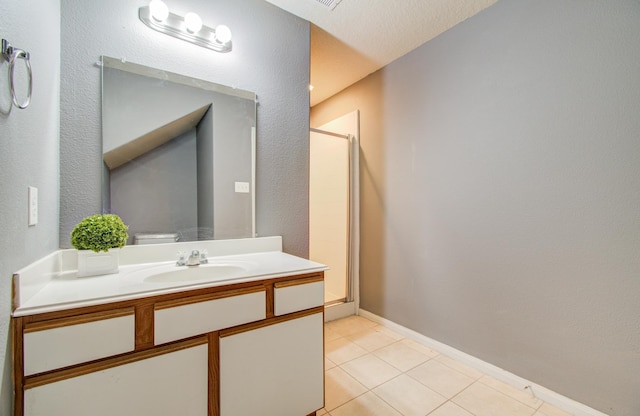 bathroom with tile patterned flooring, vanity, and a shower with door