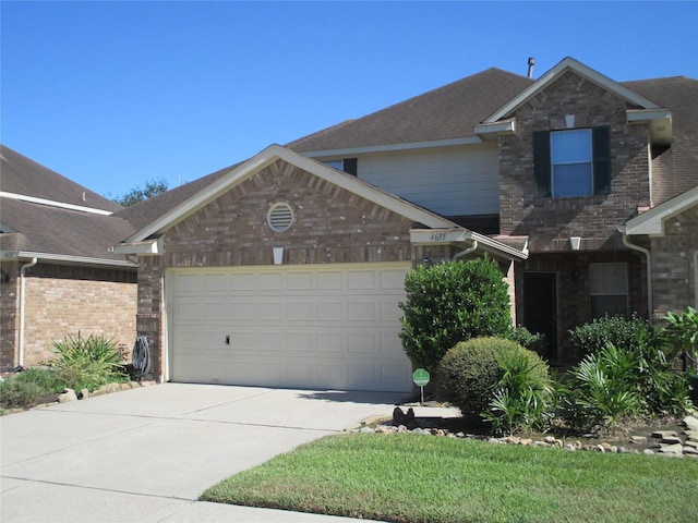 traditional-style home with concrete driveway, brick siding, and a garage