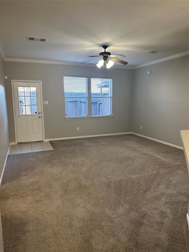interior space featuring baseboards, visible vents, ceiling fan, and crown molding
