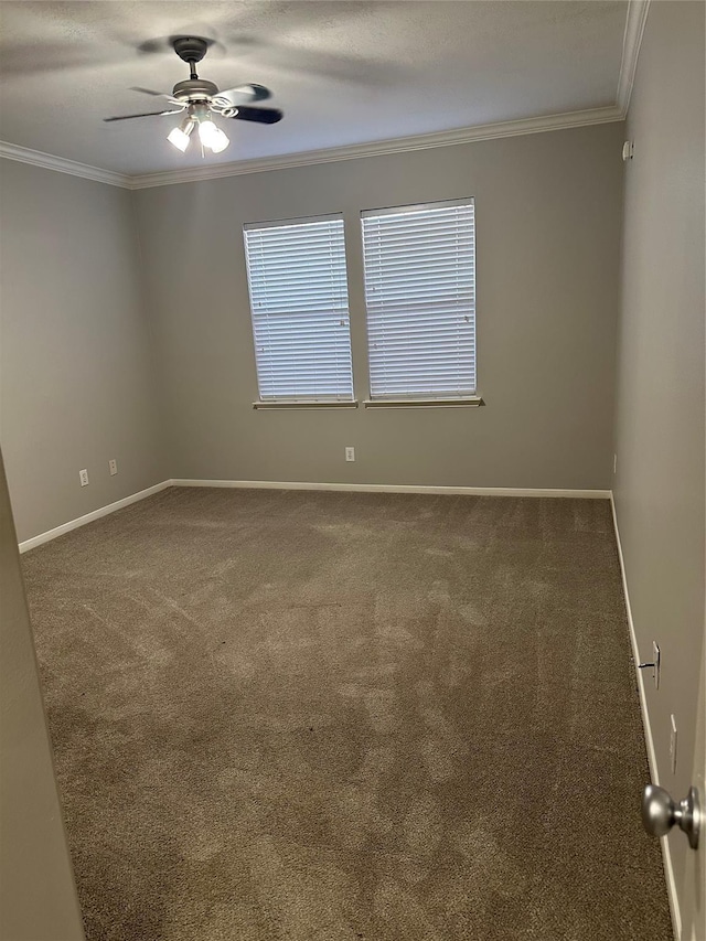 carpeted empty room with ceiling fan, baseboards, and ornamental molding