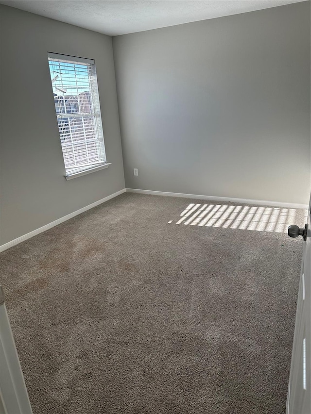 carpeted spare room with baseboards