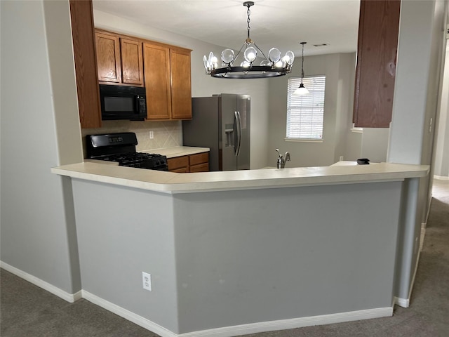 kitchen with black appliances, decorative backsplash, brown cabinets, carpet floors, and a peninsula