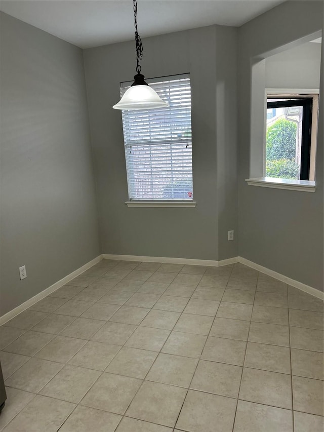spare room featuring baseboards and light tile patterned floors