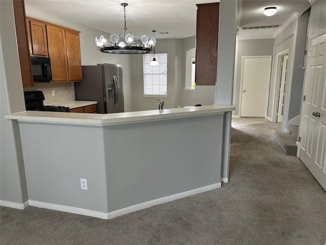 kitchen featuring visible vents, decorative backsplash, brown cabinets, carpet floors, and black appliances