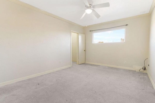 spare room featuring light carpet, crown molding, and ceiling fan