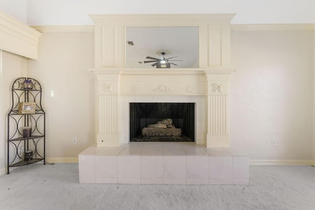 room details with a tiled fireplace, ornamental molding, carpet, and ceiling fan