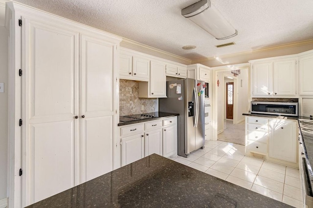 kitchen featuring crown molding, stainless steel appliances, white cabinets, light tile patterned flooring, and decorative backsplash