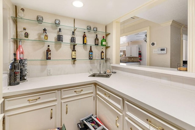 bar with crown molding, sink, and decorative backsplash