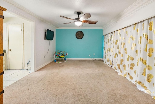 carpeted spare room with crown molding and ceiling fan