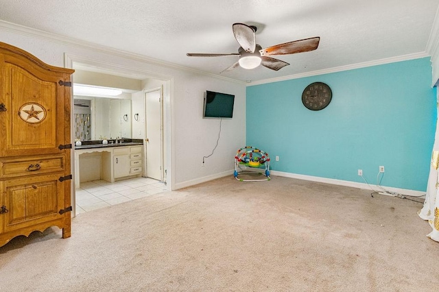 unfurnished bedroom featuring ceiling fan, light colored carpet, crown molding, and ensuite bath