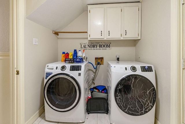 clothes washing area with cabinets and washer and dryer