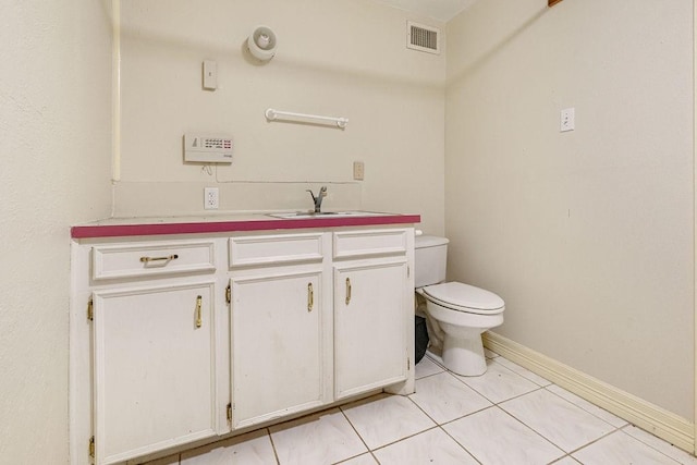 bathroom with tile patterned flooring, vanity, and toilet