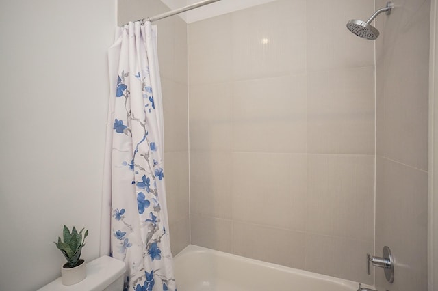 bathroom featuring shower / tub combo and toilet