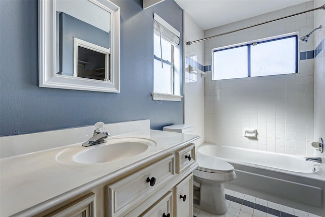 full bathroom featuring vanity, tiled shower / bath, and toilet