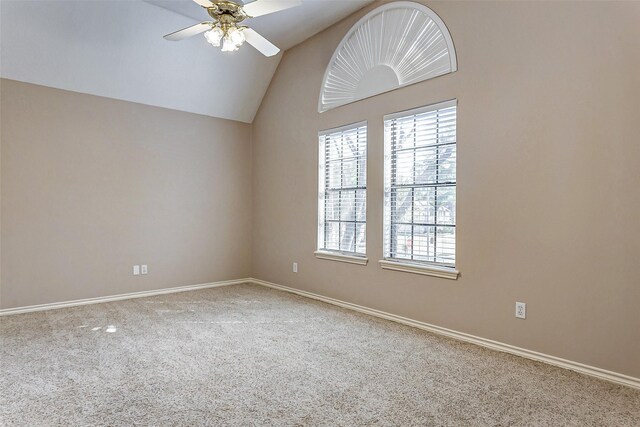 carpeted spare room featuring lofted ceiling and ceiling fan