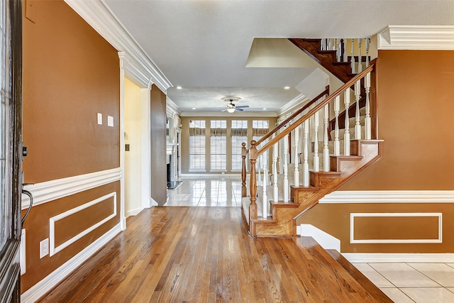 foyer with hardwood / wood-style flooring, ornamental molding, and ceiling fan