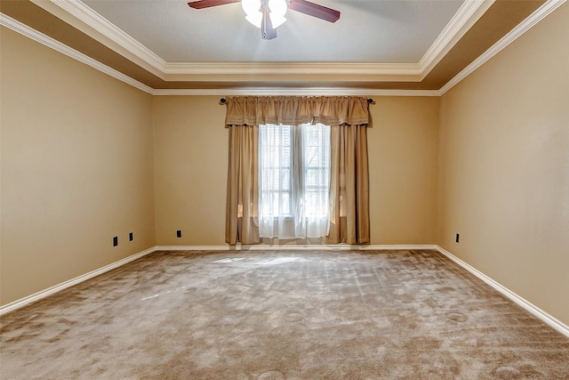 empty room featuring a raised ceiling, crown molding, carpet floors, and ceiling fan