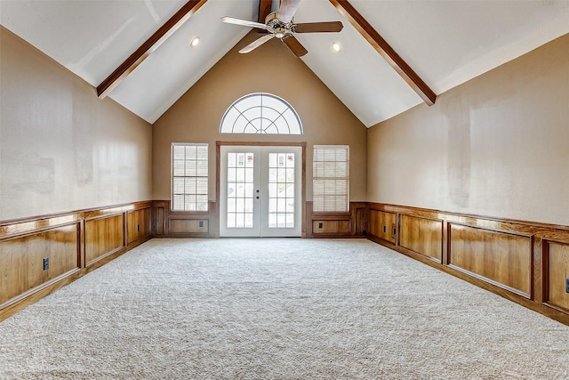 spare room with ceiling fan, high vaulted ceiling, light colored carpet, french doors, and beamed ceiling