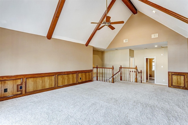 empty room with beamed ceiling, ceiling fan, high vaulted ceiling, and carpet