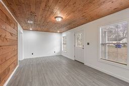 spare room with wood ceiling and dark wood-type flooring