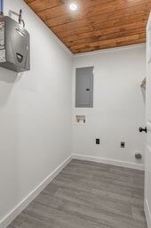 laundry area with washer hookup, dark wood-type flooring, wooden ceiling, and electric panel