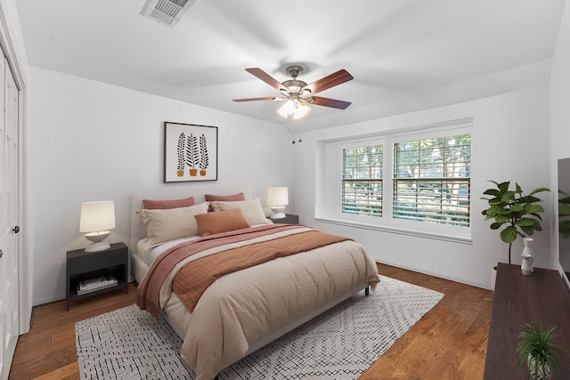 bedroom with a ceiling fan, visible vents, and dark wood-type flooring