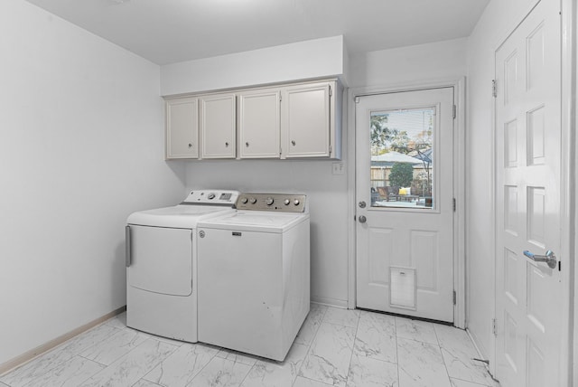 laundry room featuring marble finish floor, baseboards, washer and dryer, and cabinet space