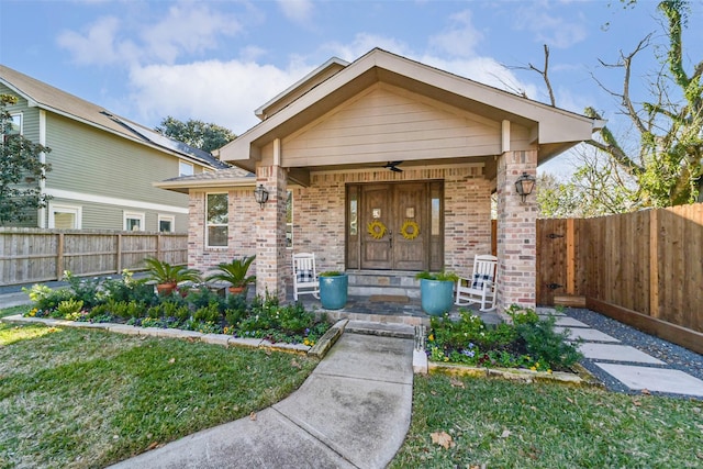 view of front of home with a front yard, ceiling fan, and a porch