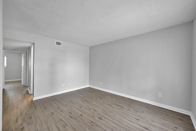 unfurnished room with hardwood / wood-style flooring