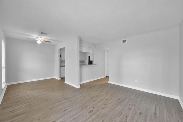 unfurnished living room featuring ceiling fan and light hardwood / wood-style floors